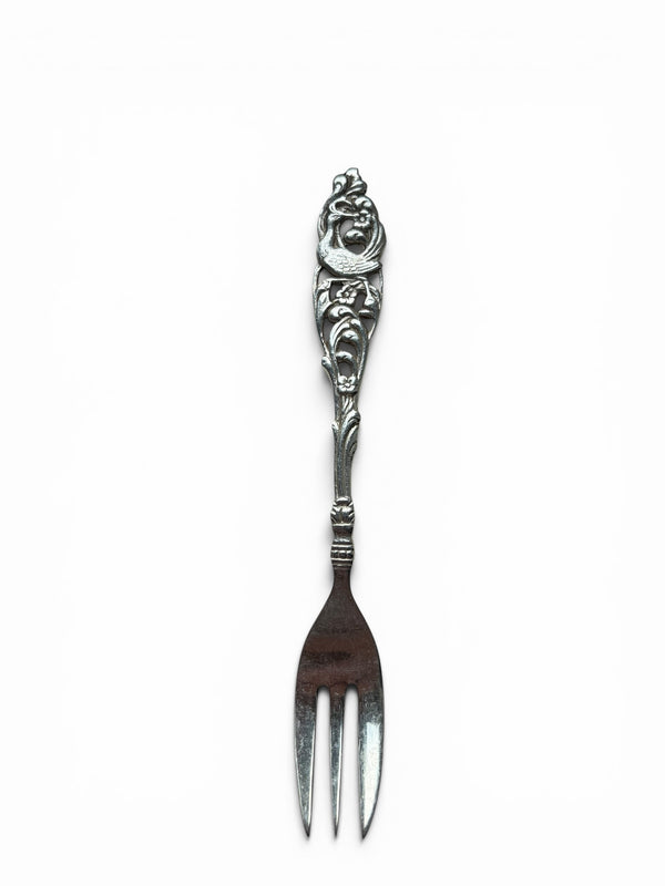Smitsjewellery vintage silver-tone pastry fork with ornate handle featuring floral relief and bird motif.