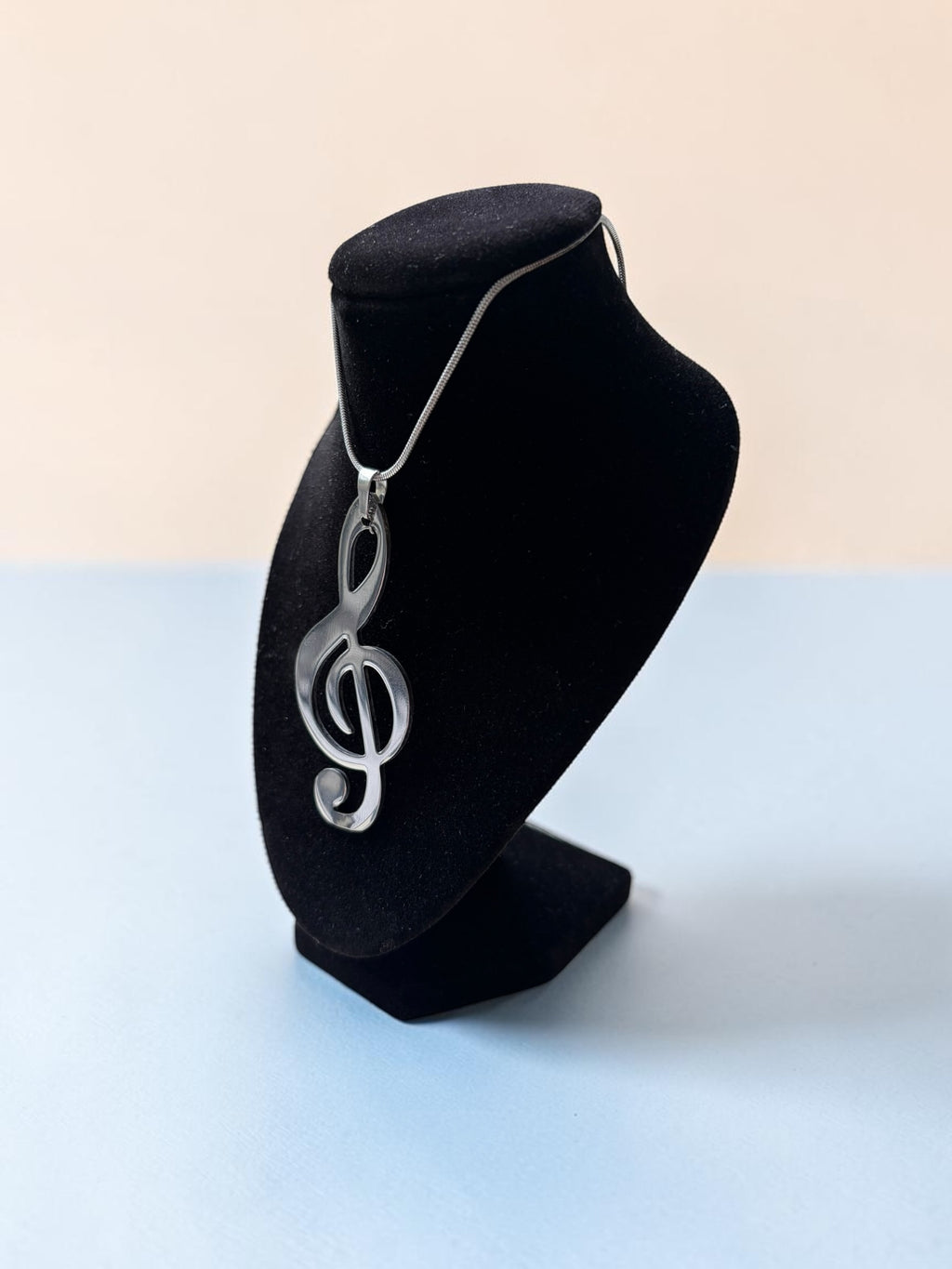 Smitsjewellery zilverkleurige vioolsleutel hanger ketting voor muziekliefhebbers op een zwarte displaystandaard.