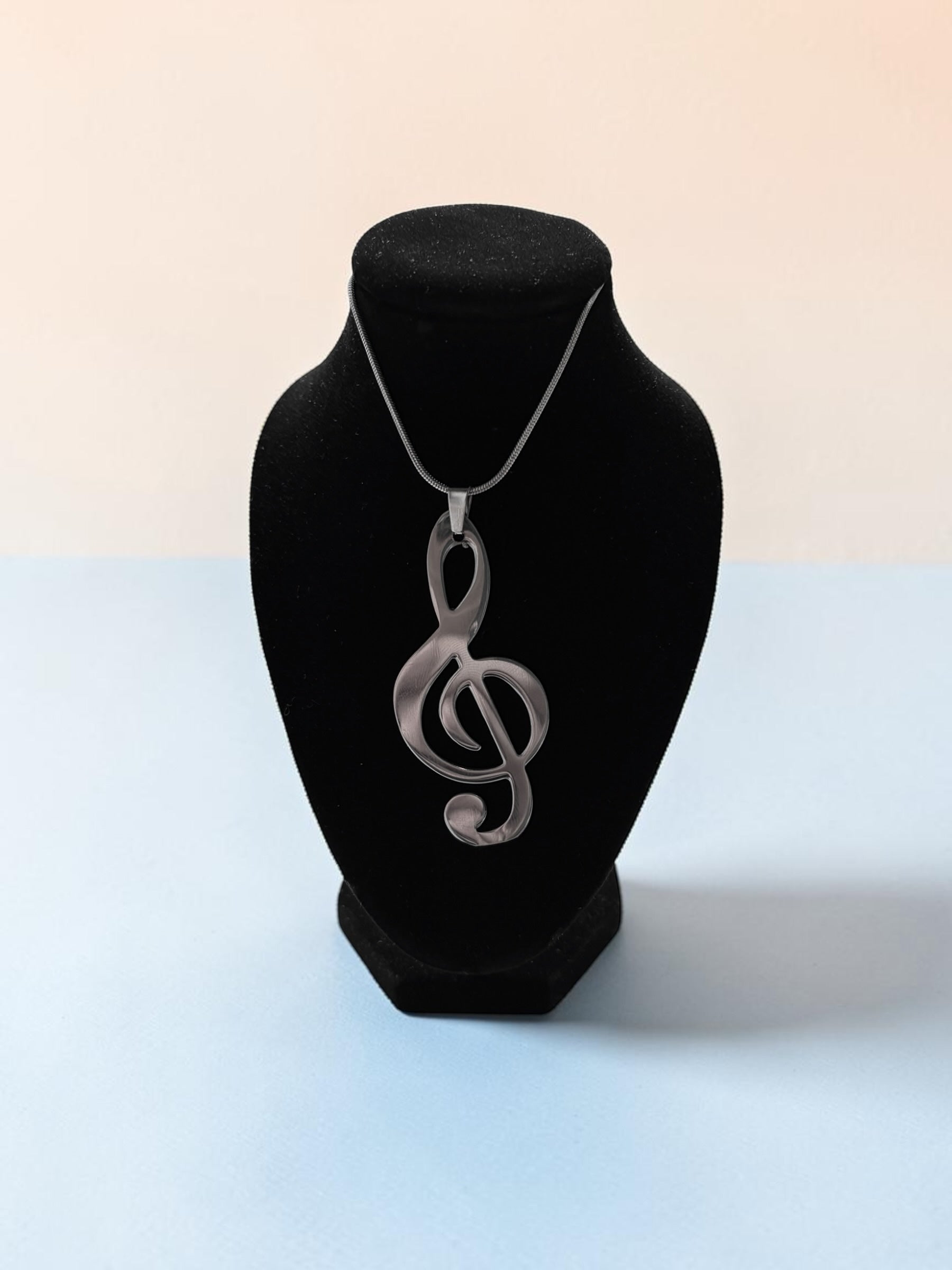 Smitsjewellery zilverkleurige vioolsleutel hanger ketting op een zwarte display buste voor muziekliefhebbers